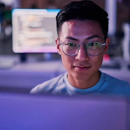 Mann mit Brille, der auf einen Computerbildschirm schaut