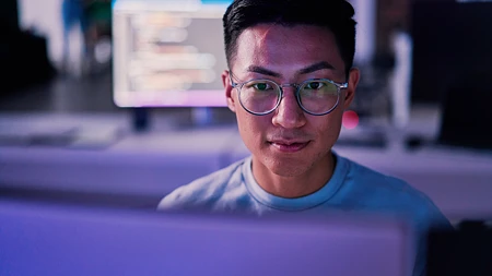 Mann mit Brille, der auf einen Computerbildschirm schaut