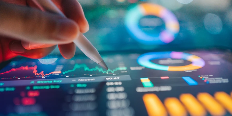 Hand mit einem digitalen Stift, der auf Finanzdiagramme und Datenvisualisierungen auf einem Tablet zeigt.