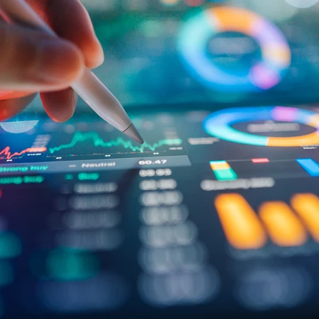 Hand mit einem digitalen Stift, der auf Finanzdiagramme und Datenvisualisierungen auf einem Tablet zeigt.