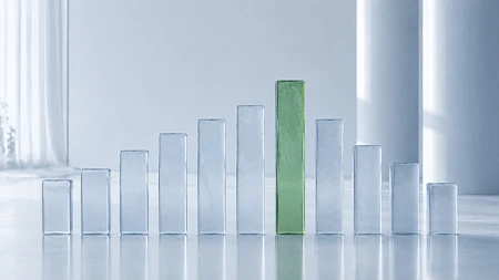 Reihe von transparenten Glasblöcken in verschiedenen Höhen, ein grüner Block steht im Zentrum.